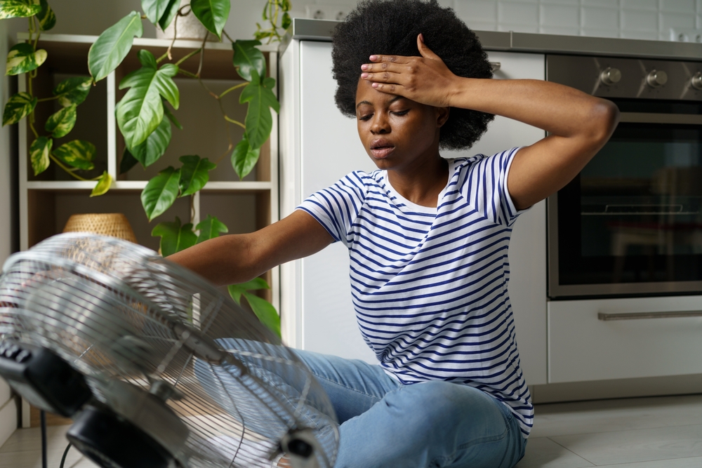 Unhappy,African,Woman,Touching,Forehead,Having,Hot,Flashes,Using,Electric