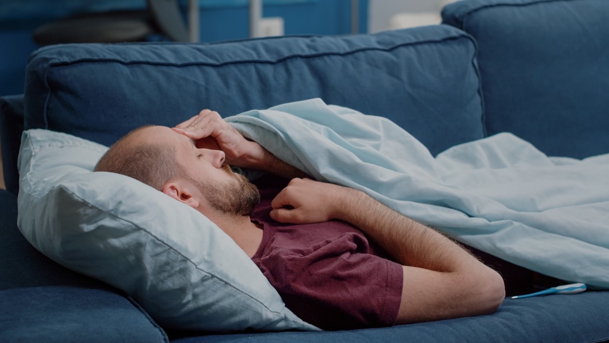 Blog 1 sick man looking thermometer check fever measurement while sleeping ill person holding medical instrument measuring temperature resting blanket unwell adult with illness ()